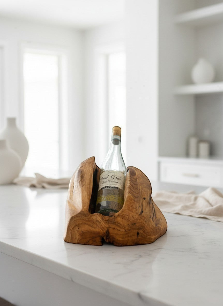 Natural Wonders USA cedar single bottle wine holder with a rustic, carved design, holding a bottle of white wine on a marble countertop.