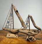 Natural Wonders USA sea glass and driftwood boat sculpture with blue and white sails on a wooden base. Nautical decor.