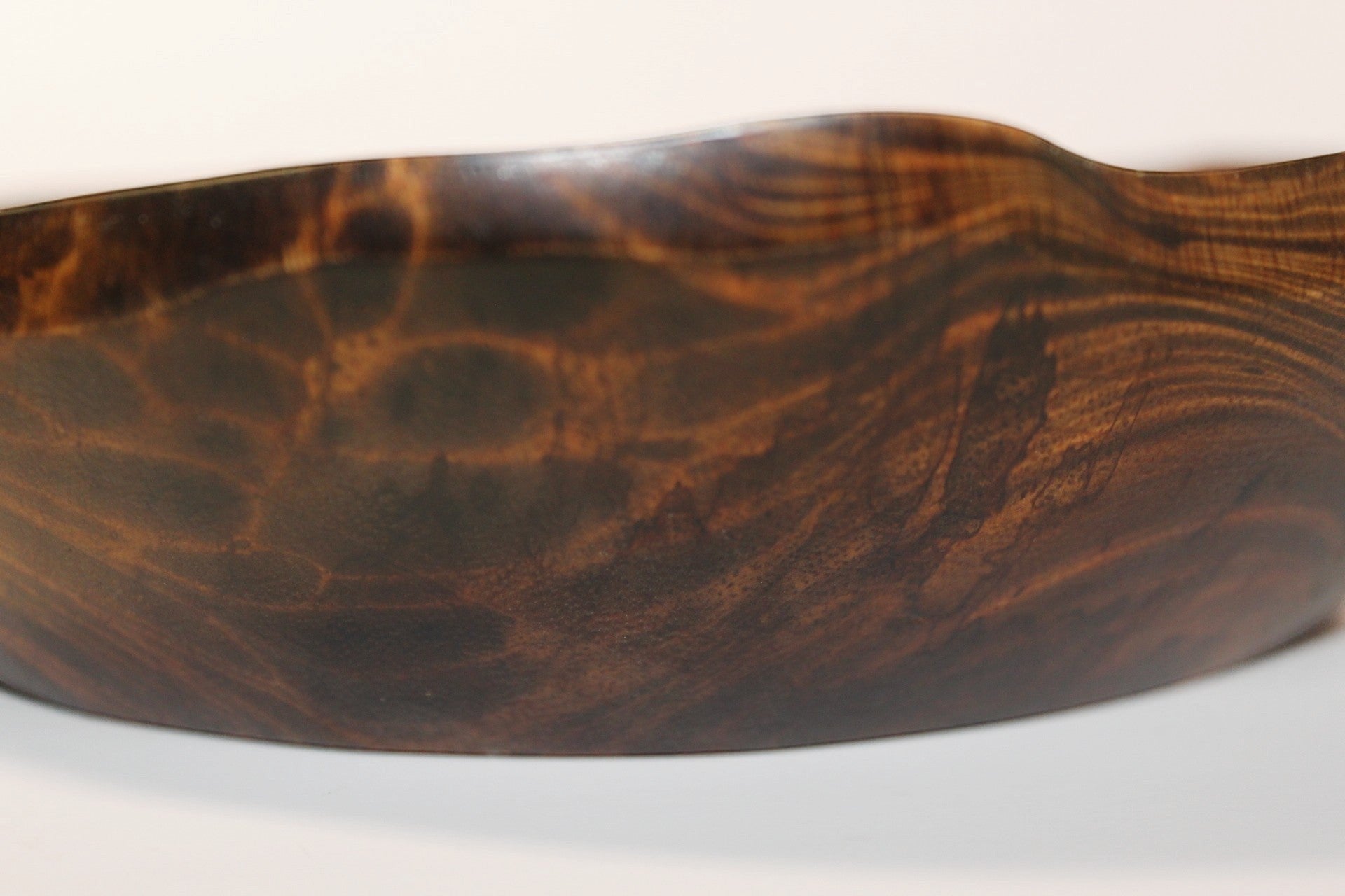 Natural Wonders USA hand carved dark wood serving bowl with organic shape and captivating grain patterns.