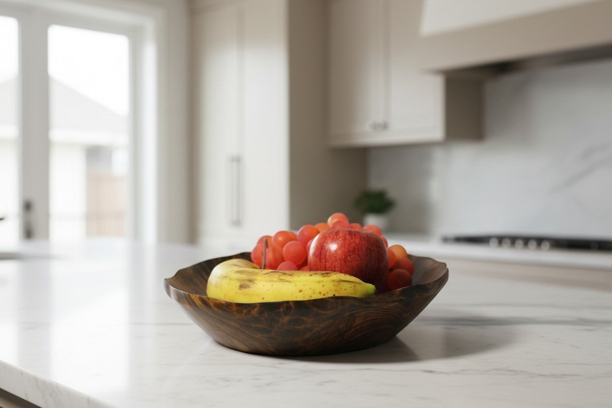 Natural Wonders USA hand carved dark wood serving bowl with organic shape, filled with red apple, grapes, and banana.