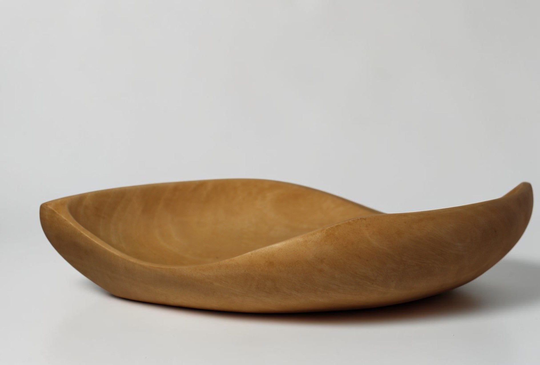 Natural Wonders USA hand carved light wood serving bowl with organic shape and matte finish.