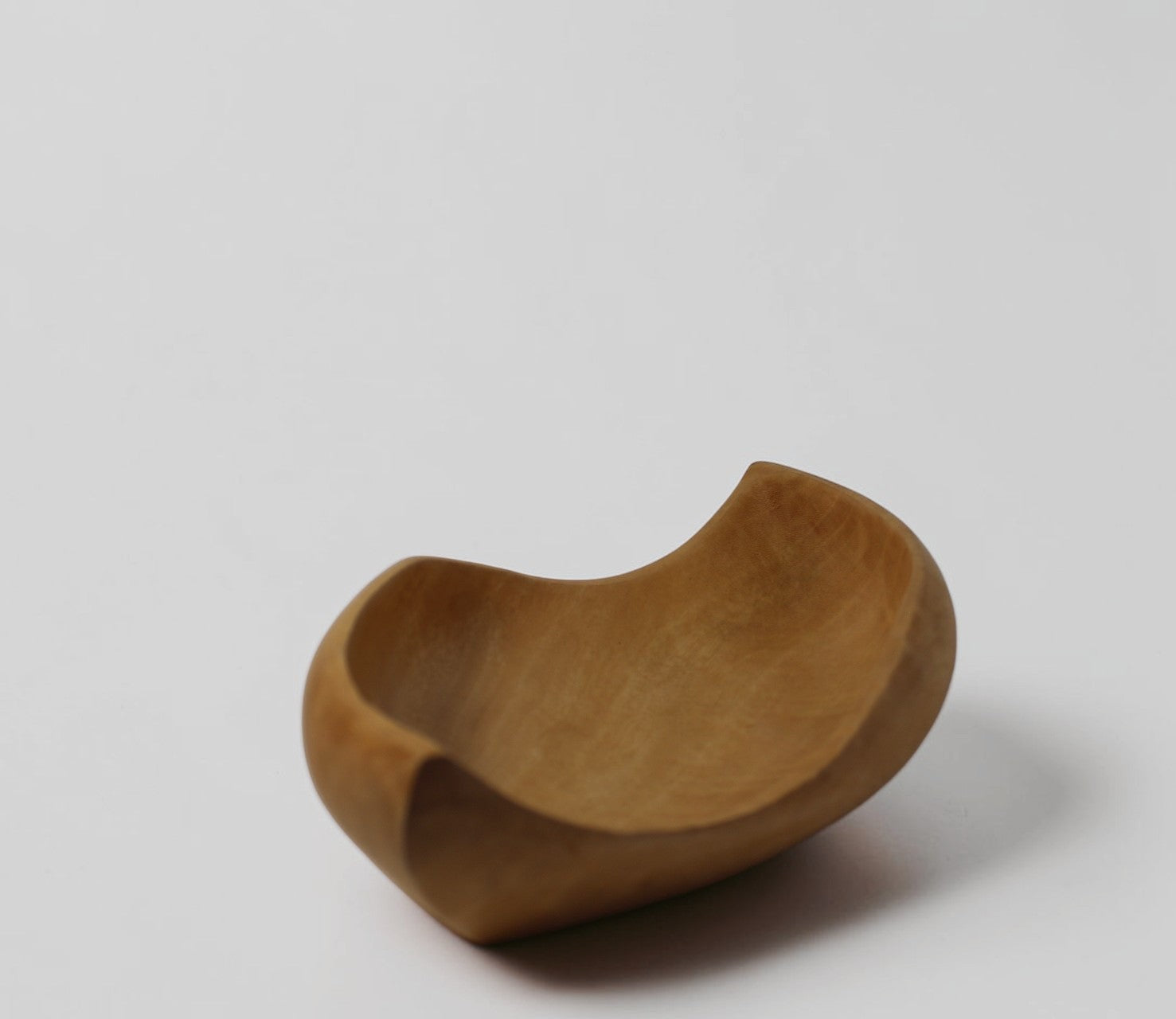 Natural Wonders USA hand-carved light wood serving bowl with organic, flowing shape and matte finish.