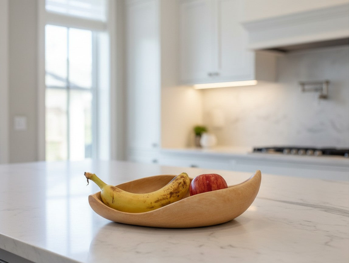 Natural Wonders USA light wood serving bowl with organic shape, holding a banana and an apple.