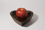 Natural Wonders USA dark wood heart-shaped serving bowl with a red apple inside. Rustic charm.