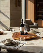 Natural Wonders USA 16" round teakwood lazy Susan with a bottle of red wine and decorative grapes.