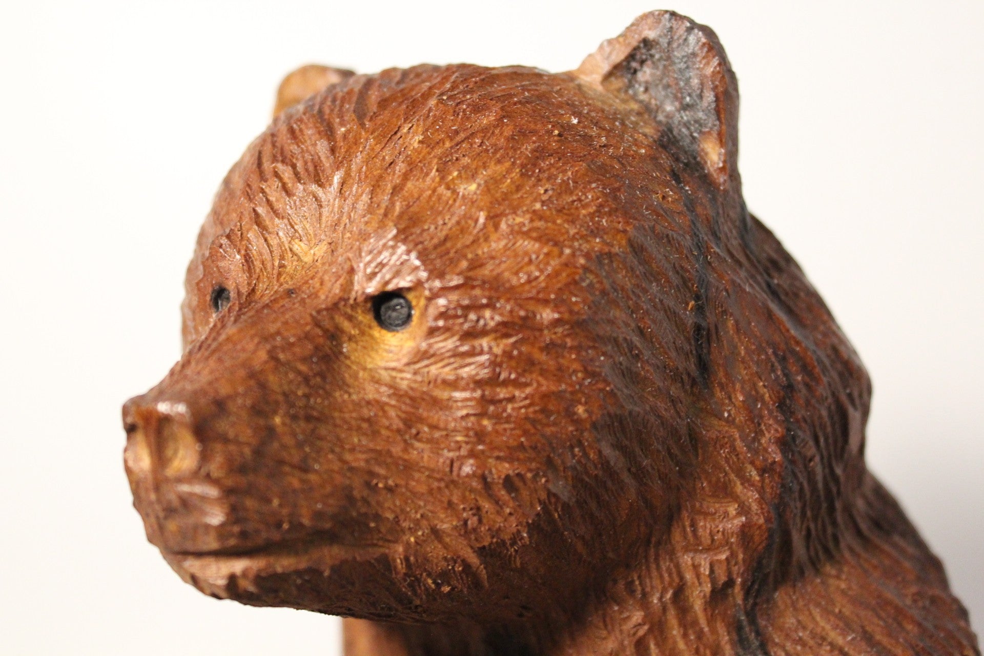 Rustic hand-carved wooden bear figurine from Natural Wonders USA, showcasing intricate details and warm, earthy tones.