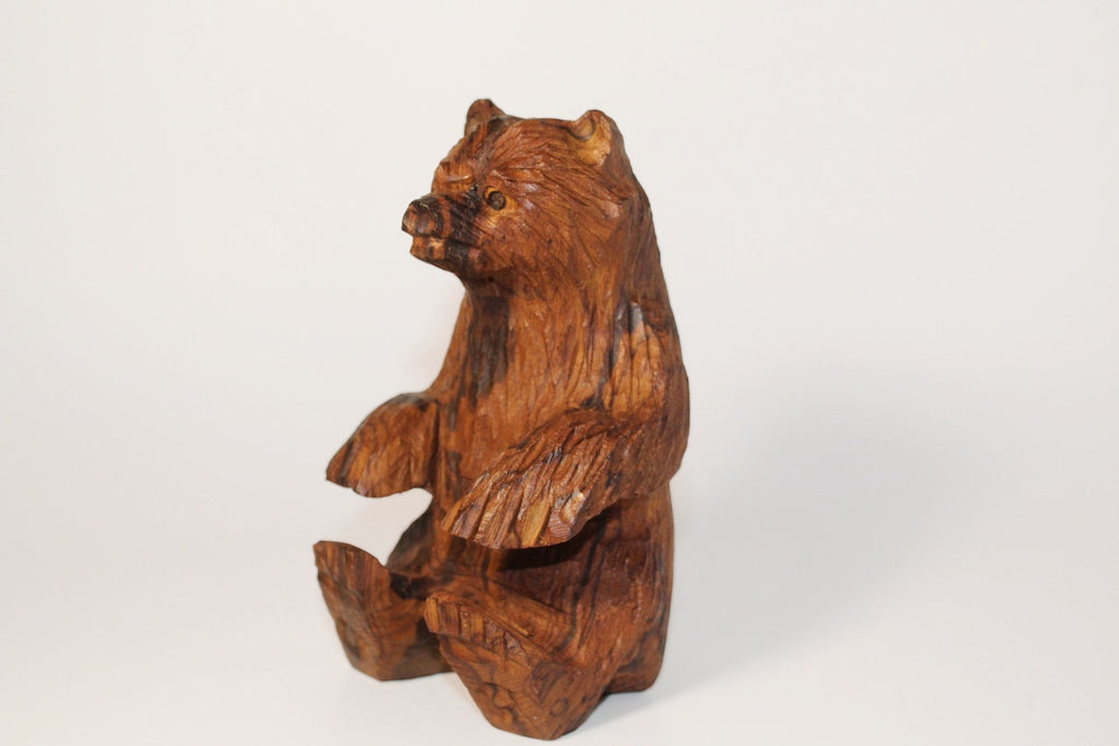 Natural Wonders USA rustic hand carved wooden bear figurine, seated position, detailed wood grain, warm earthy tones.