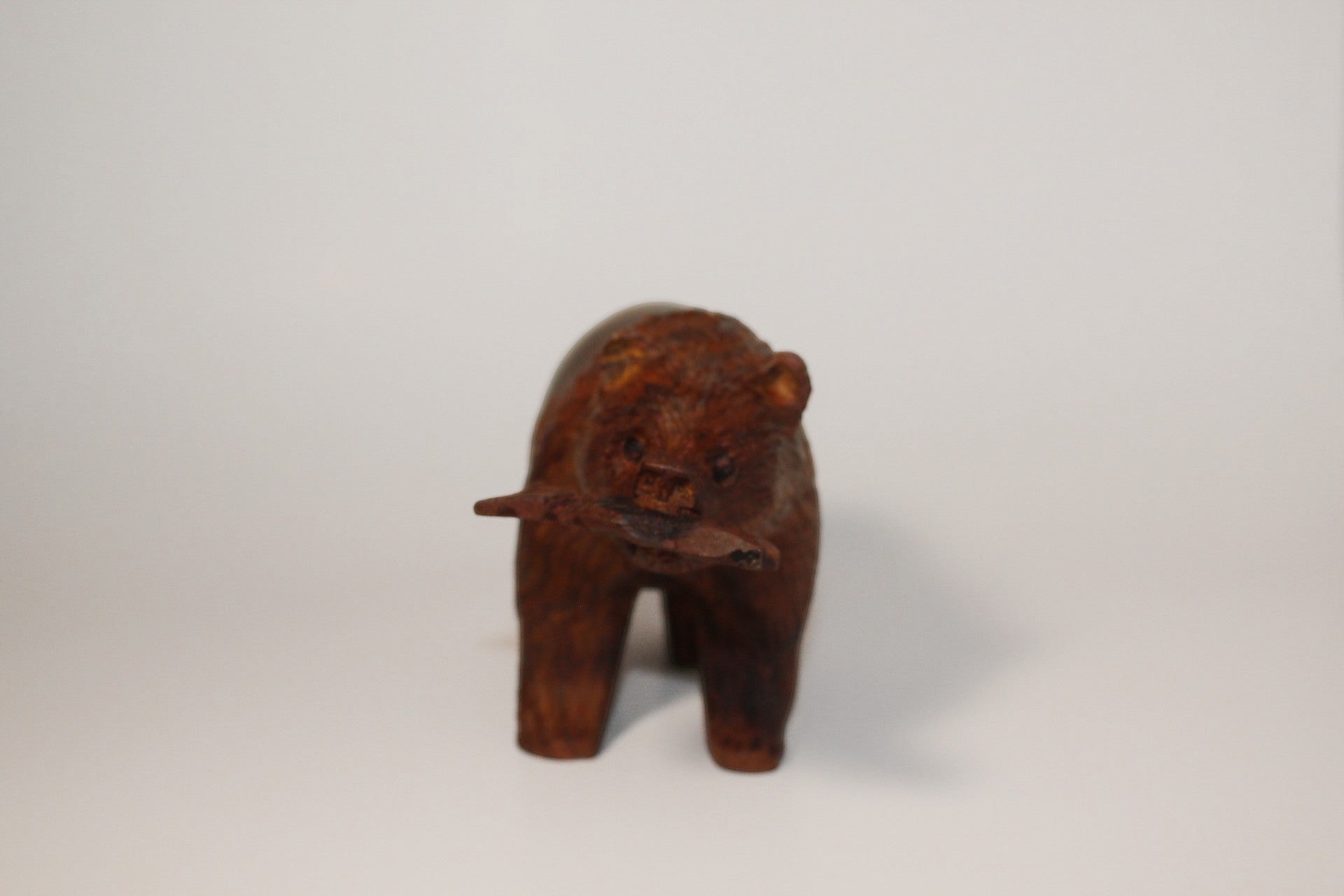 Natural Wonders USA hand-carved dark wood bear figurine with fish in mouth. Rustic, detailed sculpture.