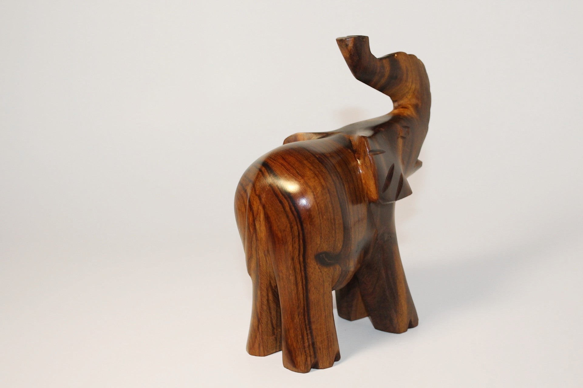 Natural Wonders USA dark wood elephant figurine with raised trunk, carved details, and natural grain.