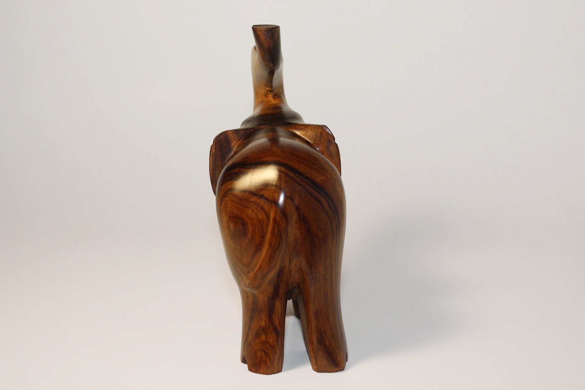 Natural Wonders USA dark wood elephant figurine with raised trunk, carved details, and natural grain.