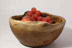 Natural Wonders USA rustic wooden serving bowl with irregular rim, filled with red grapes and an apple.