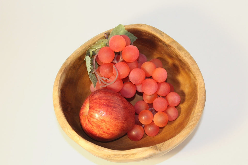 Natural Wonders USA rustic wooden serving bowl with organic shape and irregular rim, filled with red apple and coral grapes.