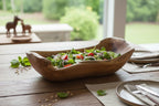Natural Wonders USA rustic wooden trough bowl filled with salad, featuring a free-form shape and natural grain.